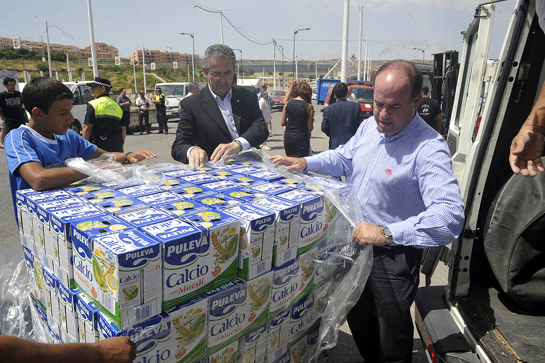 El Alcalde y el Teniente de Alcalde de Familia ayudando a la carga de envases de leche en una de las furgonetas con destino la res...