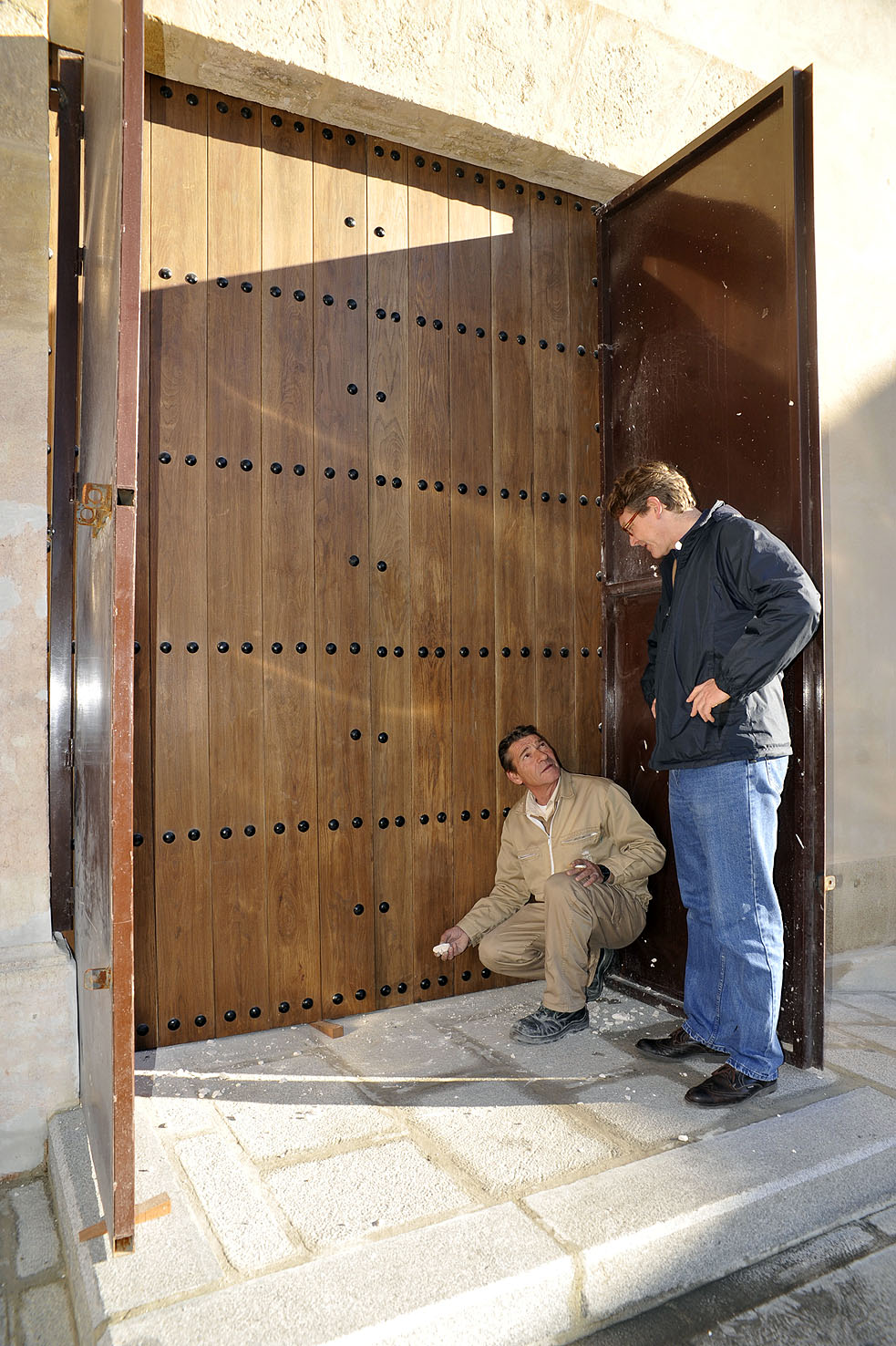 El padre trinitario Antonio Elverfeldt inspeccionando la instalación de la nueva puerta que facilitará el acceso a personas con mo...